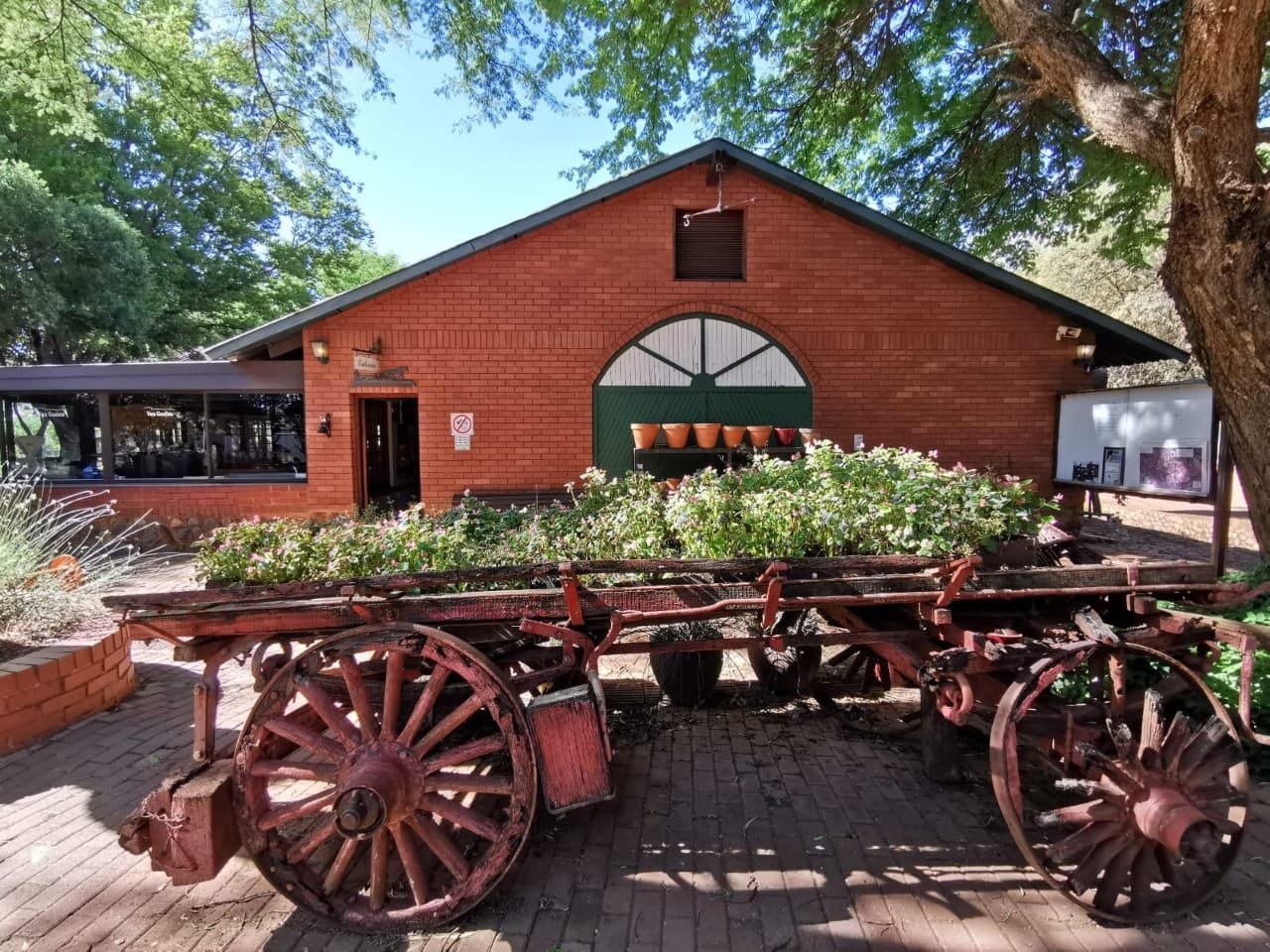 The historic red-brick Van Gaalen farm building with its vintage ox-wagon, Skeerpoort
