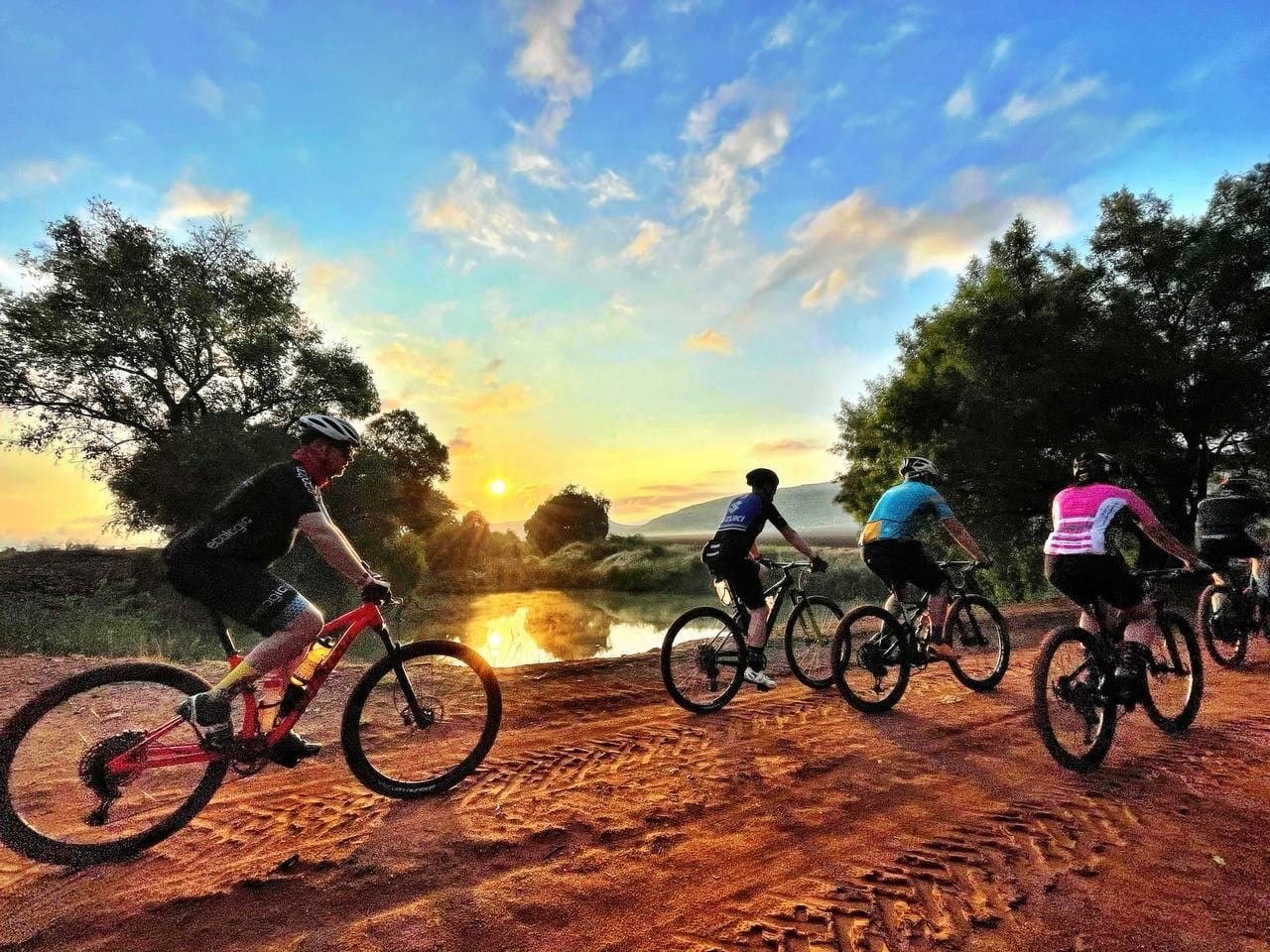 A group of mountain bikers riding out at sunset on the Van Gaalen trails