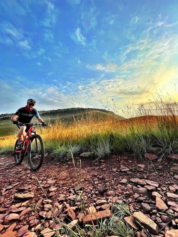 Rider on the rocky Railway link trail with the Magaliesberg beyond